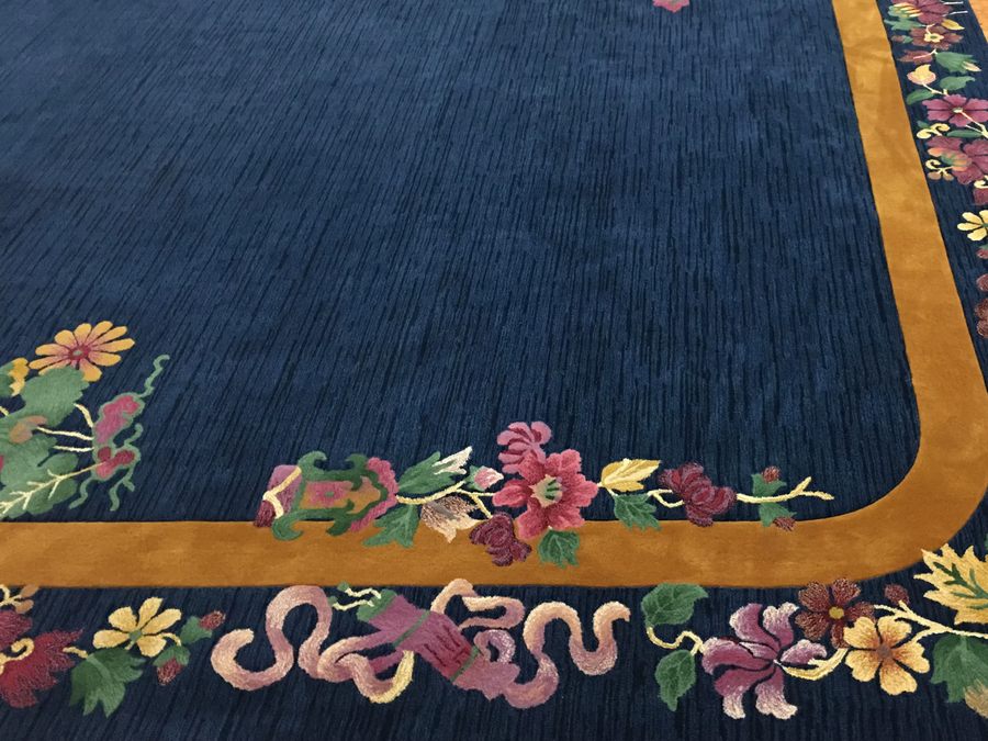 Navy rug with a gold border and floral corner work